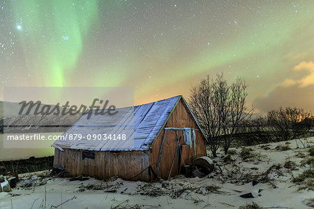 The Northern Lights Illuminates The Wooden Cabin Svensby Lyngen