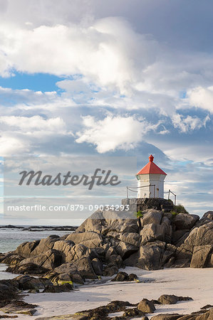 Midnight sun lights up lighthouse on cliffs surrounded by turquoise sea Eggum Unstad Vestvagøy Lofoten Islands Norway Europe