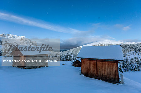 Two wooden lodges covered in snow. Passo delle Erbe, Bolzano, Trentino Alto Adige - Sudtirol, Italy, Europe.