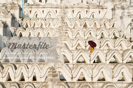 Mingun, Sagaing region, Myanmar (Burma). Woman with red umbrella in the middle of the white terraces of the Hsinbyume white pagoda.