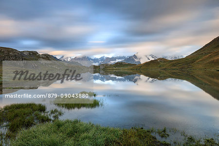 The snowy peaks are reflected in Fenetre Lakes at dawn Ferret Valley Saint Rhémy Grand St Bernard Aosta Valley Italy Europe