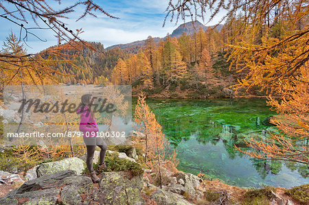 A tourist staring at the small lake near Crampiolo known as Witches Lake, Alpe Veglia and Alpe Devero Natural Park, Baceno, Verbano Cusio Ossola province, Piedmont, Italy