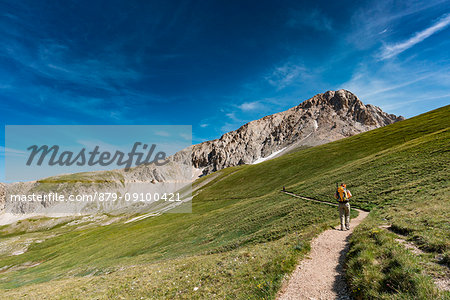 Trekker walking towards Gran Sasso, Campo Imperatore, L'Aquila province, Abruzzo, Italy, Europe Trekker walking towards Gran Sasso, Campo Imperatore, L'Aquila province, Abruzzo, Italy, Europe