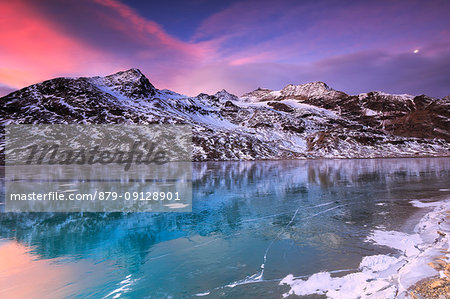 Stunning sunrise on the frozen Lago Bianco(White Lake), Bernina Pass, Engadine, Graubünden, Switzerland.