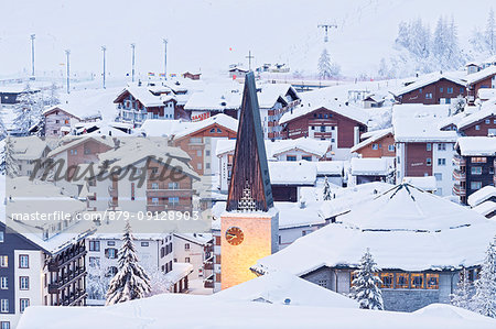 Illuminated bell tower of the church of Saas Fee after a snowfall. Saas Fee, Canton of Valais / Wallis, Switzerland.