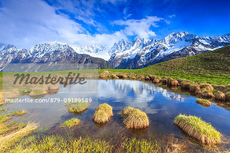 Masino-Bregaglia group with Pizzo Badile are mirrored in a seasonal lake. Soglio, Val Bregaglia(Bregaglia Valley), Graubünden, Switzerland, Europe.