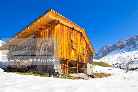 Typical huts in Partnun with Ratikon mountain range in the background. Partnun, Prattigau valley, District of Prattigau/Davos, Canton of Graubünden, Switzerland, Europe.