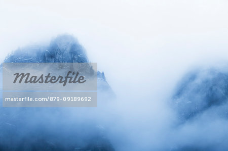 Mountain of the Mello Valley hidden by clouds. Val di Mello, Valmasino, Valtellina, Lombardy, Italy, Europe.