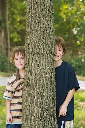 simsearch:400-04449607,k - Two Boys Peeking Around a Tree Playing Photographie de stock - Aubaine LD & Abonnement, Code: 400-04004685