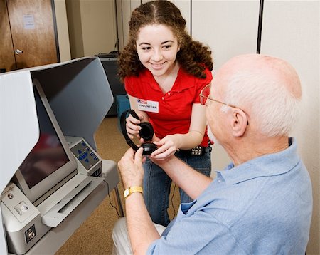 Helpful election volunteer provides headphones to assist a senior man in voting on new touch screen machine. Stock Photo - Budget Royalty-Free & Subscription, Code: 400-04005685