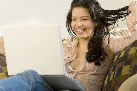 simsearch:400-04340722,k - A beautiful young Hispanic woman using her laptop and laughing Stock Photo - Budget Royalty-Free & Subscription, Code: 400-04005978