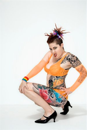 Adult caucasian woman with tattoos squatting on floor. Photographie de stock - Aubaine LD & Abonnement, Code: 400-04006136
