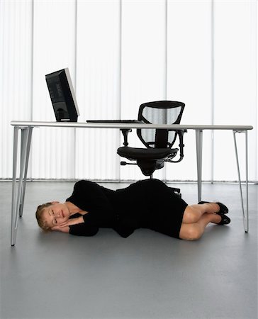 Caucasian businesswoman sleeping on floor under computer desk. Stock Photo - Budget Royalty-Free & Subscription, Code: 400-04006179