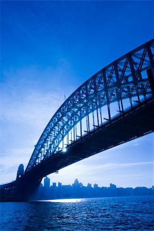 simsearch:400-04006297,k - Sydney Harbour Bridge at dusk with view of distant skyline and harbour in Sydney, Australia. Foto de stock - Royalty-Free Super Valor e Assinatura, Número: 400-04006305