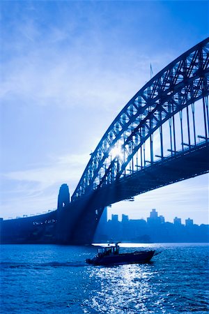 simsearch:400-04006297,k - Boat under Sydney Harbour Bridge at dusk with view of distant skyline and harbour in Sydney, Australia. Foto de stock - Royalty-Free Super Valor e Assinatura, Número: 400-04006306