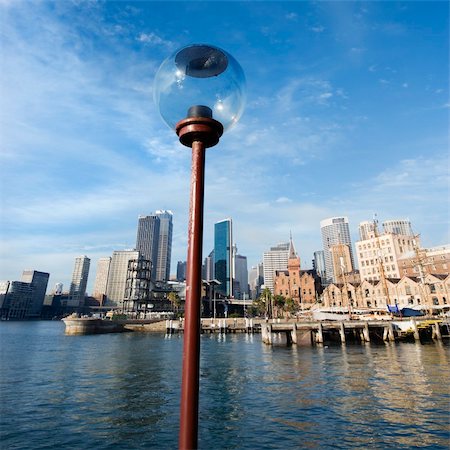 simsearch:400-04006297,k - Lamppost in  Sydney Cove with city skyline and water in Sydney, Australia. Foto de stock - Royalty-Free Super Valor e Assinatura, Número: 400-04006308