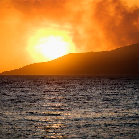 simsearch:400-04006465,k - Sun setting behind mountain with ocean at Maui, Hawaii. Photographie de stock - Aubaine LD & Abonnement, Code: 400-04006466