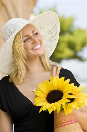 simsearch:400-04058311,k - A beautiful young blond woman wearing a sun hat and smiling while carrying a shopping bag of sunflowers Foto de stock - Super Valor sin royalties y Suscripción, Código: 400-04008245