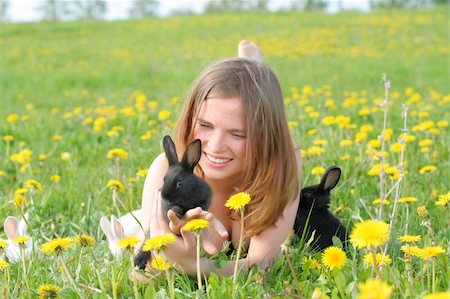 simsearch:400-07918929,k - Beautiful young girl lays in grass and plays with cute small rabbits Stockbilder - Microstock & Abonnement, Bildnummer: 400-04008839
