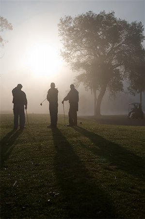 Early morning golfers silhouetted in a dense fog with a rising sun Stock Photo - Budget Royalty-Free & Subscription, Code: 400-04000378