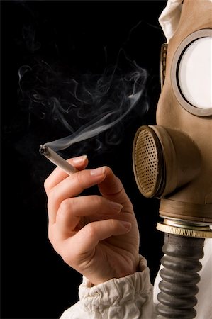 Person in gas mask smoking cigarette on dark background Stock Photo - Budget Royalty-Free & Subscription, Code: 400-04001697