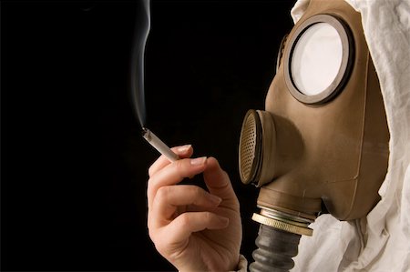 Person in gas mask smoking cigarette on dark background Stock Photo - Budget Royalty-Free & Subscription, Code: 400-04001698