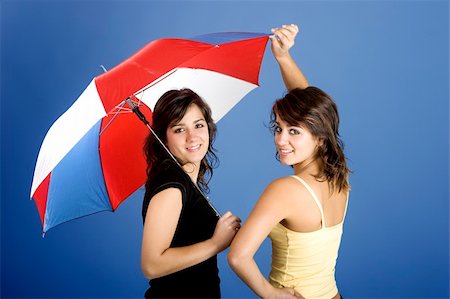 simsearch:400-03996893,k - Beautiful young twins posing with an umbrella on a blue background Stock Photo - Budget Royalty-Free & Subscription, Code: 400-04001772