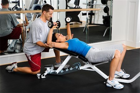 spotting at the gym - Man assisting woman at gym with hand weights smiling. Stock Photo - Budget Royalty-Free & Subscription, Code: 400-04002894