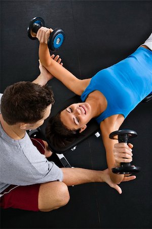 posição - Man assisting woman lifting weights at gym. Foto de stock - Royalty-Free Super Valor e Assinatura, Número: 400-04002902