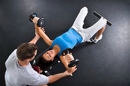 simsearch:400-07620929,k - Man assisting woman lifting weights at gym. Stock Photo - Budget Royalty-Free & Subscription, Code: 400-04002903