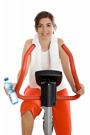 simsearch:400-07103428,k - Young woman training on exercise bike at the gym whit a bottle of water on the left hand Photographie de stock - Aubaine LD & Abonnement, Code: 400-04003194
