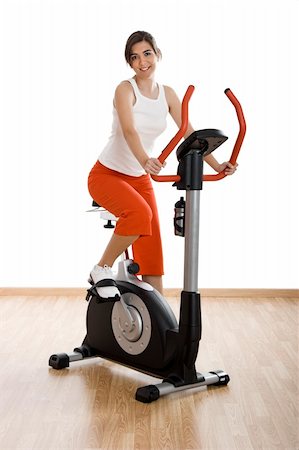 simsearch:400-07103428,k - Young woman training on exercise bike at the gym Photographie de stock - Aubaine LD & Abonnement, Code: 400-04003197
