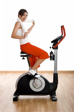 simsearch:400-07103428,k - Young woman training on exercise bike at the gym Photographie de stock - Aubaine LD & Abonnement, Code: 400-04003192