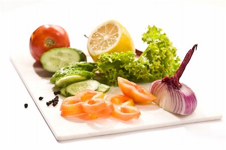 Vegetable mix: lettuce, onion, lemon, cucumber on the board Stock Photo - Budget Royalty-Free & Subscription, Code: 400-04014816
