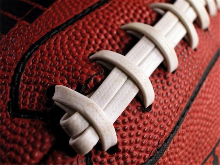 pigskin - Close-up shot showing the white laces and dimpled surface of an American football. Photographie de stock - Aubaine LD & Abonnement, Code: 400-04014975