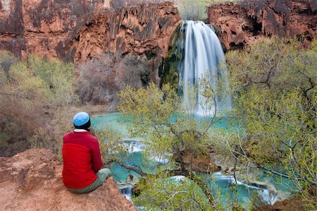 simsearch:862-08274100,k - Woman sitting at the edge of a cliff watching Havasu Falls drop into it's turquoise pool. Havasu Canyon, Arizona. Havsupai Reservation. Foto de stock - Royalty-Free Super Valor e Assinatura, Número: 400-04015111
