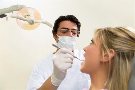 simsearch:400-04016093,k - young woman doing dental checkup. Dentist is using an angled mirror Photographie de stock - Aubaine LD & Abonnement, Code: 400-04015318