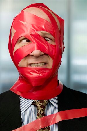 suit bound - Cross-eyed businessman wrapped in red tape Stock Photo - Budget Royalty-Free & Subscription, Code: 400-04015927