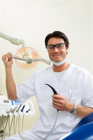 dentist turning on examination light Stock Photo - Budget Royalty-Free & Subscription, Code: 400-04016091