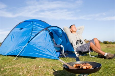 Man relaxing outside a tent on camping trip Stock Photo - Budget Royalty-Free & Subscription, Code: 400-04016896