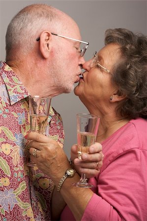 simsearch:400-04435288,k - Happy Senior Couple Kissing while holding Champagne glasses. Photographie de stock - Aubaine LD & Abonnement, Code: 400-04017415