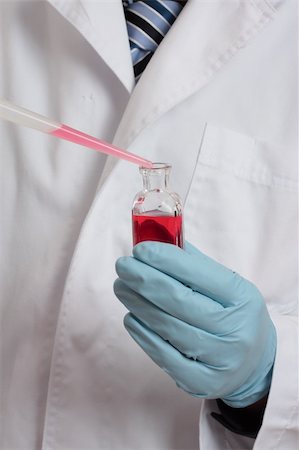 simsearch:400-04962353,k - Scientist, chemist, pharmacist or laboratory technician adding a pipetted sample to a laboratory bottle. Focus to hand, pipet and bottle Stock Photo - Budget Royalty-Free & Subscription, Code: 400-04017588