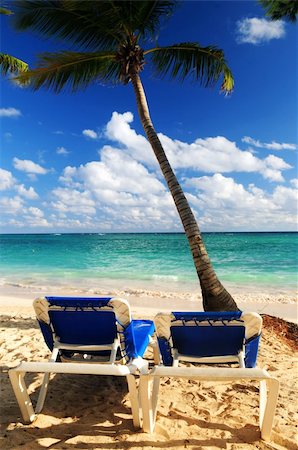 Sandy beach of tropical resort with palm trees and two reclining chairs Stock Photo - Budget Royalty-Free & Subscription, Code: 400-04017681