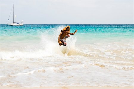 A teenage skimboarder performs a spectacular jump from a wave against a stunning backdrop of turquoise waters in the Cape Verde islands. Foto de stock - Super Valor sin royalties y Suscripción, Código: 400-04018374