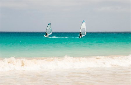 Two winsurfers race race across the beautiful turquoise waters of the Cape Verde islands. Foto de stock - Super Valor sin royalties y Suscripción, Código: 400-04018373