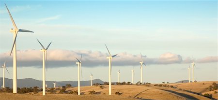 simsearch:400-04024418,k - Large wind turbines line up along the hilltop as part of an energy producing windfarm. Fotografie stock - Microstock e Abbonamento, Codice: 400-04019022