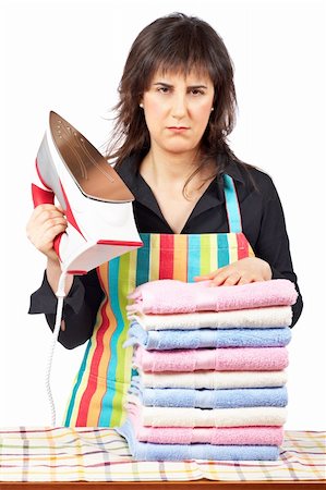 Furious housewife in apron holding a eletric iron close to towels stacked Stock Photo - Budget Royalty-Free & Subscription, Code: 400-04019890