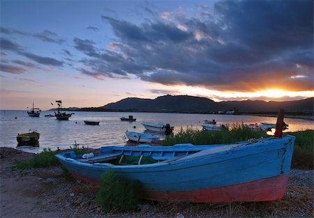 sonrisa sardónica - Beautiful sunset over harbor with a ship detail with dramatic sky on Sardinia Stock Photo - Budget Royalty-Free & Subscription, Code: 400-04010196