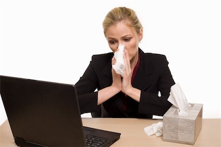 Attractive blond woman secretary sitting at office desk with a box of kleenex tissue on the desk while blowing her nose Stock Photo - Budget Royalty-Free & Subscription, Code: 400-04012544