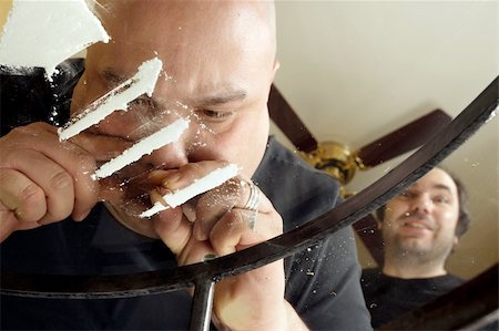 snort - An image about drug abuse.  Male snorting lines of cocaine on a dirty glass table while another waits his turn.  View from underneath and through the glass. Stock Photo - Budget Royalty-Free & Subscription, Code: 400-04012652